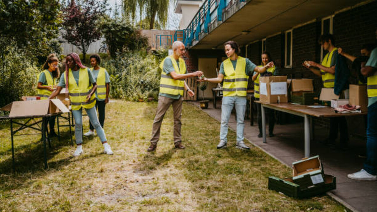 Volunteers in safety vests sorting donations together at a community charity event.