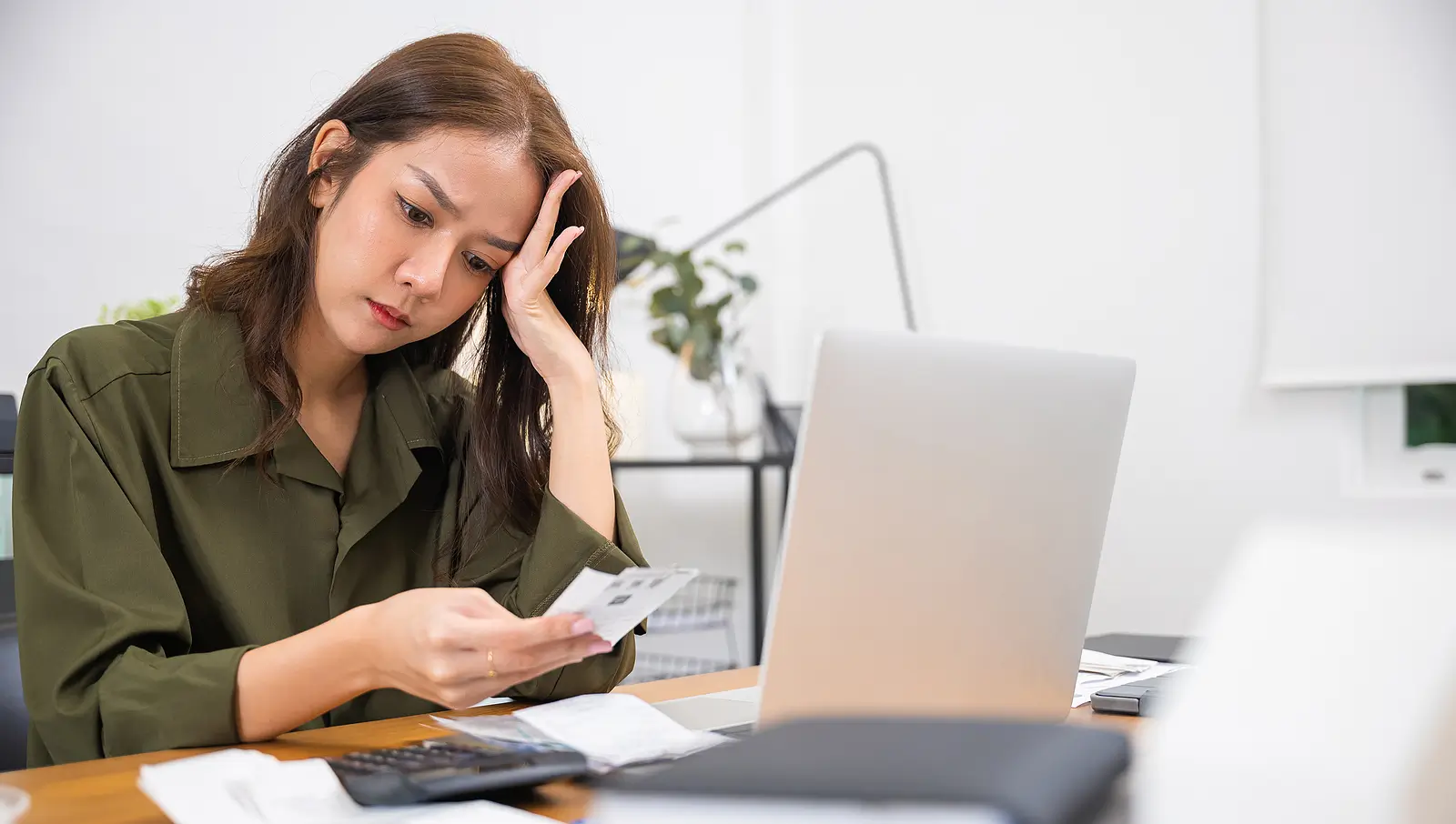 Stressed landlord reviewing property bills and paperwork, illustrating the signs that it is time to hire a professional property manager.